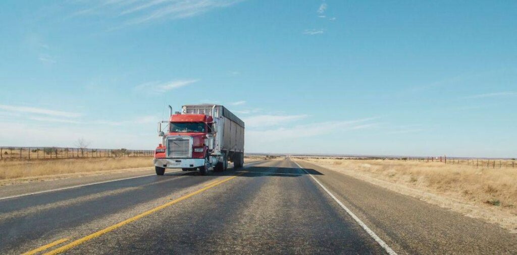 A semi truck driving down the road on a sunny day