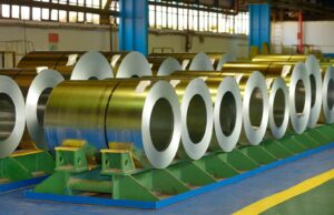 Coiled steel sheets sitting inside a steel processing facility.