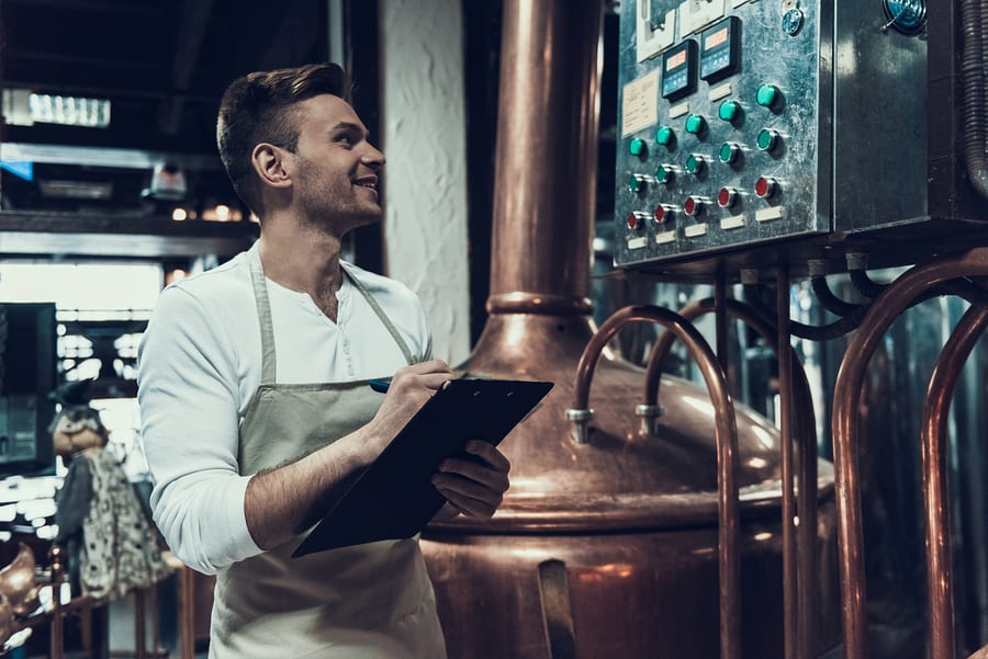 A brewery worker recording the performance of brewing equipment
