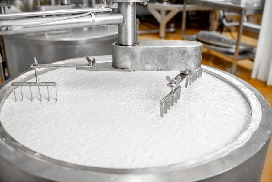 Milk being mixed in a used stainless steel tank at a dairy processing factory. 